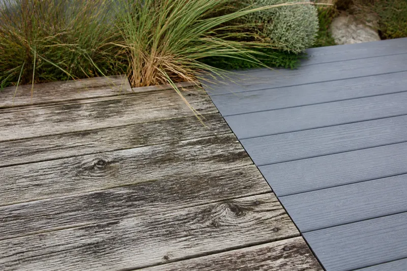 Weathered timber boards beside new composite decking